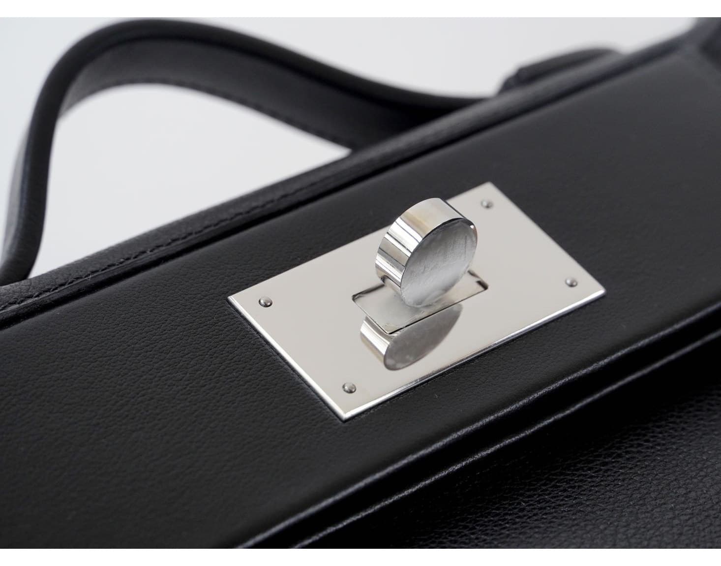 Front view of an Etoupe grey pebbled leather mini doctor bag with white contrast stitching and silver hardware, placed on a white woven stool - 4