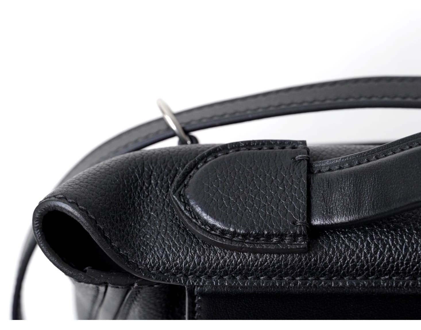 Front view of an Etoupe grey pebbled leather mini doctor bag with white contrast stitching and silver hardware, placed on a white woven stool - 8