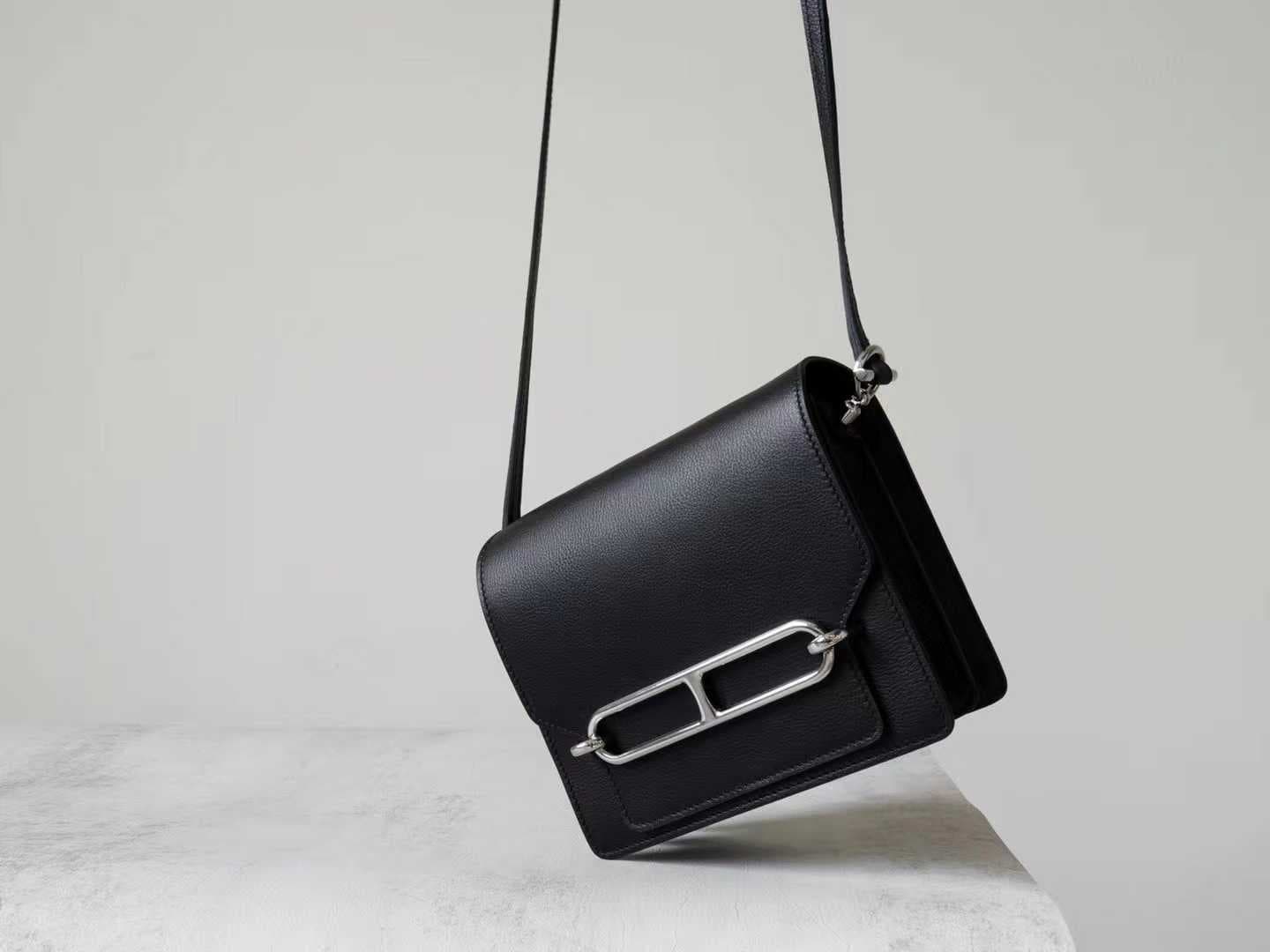 Front view of LINJIN LUXURY Roulis 18 shoulder bag in black Evercolor leather, showcasing the silver anchor-link buckle on a woven stool - 3