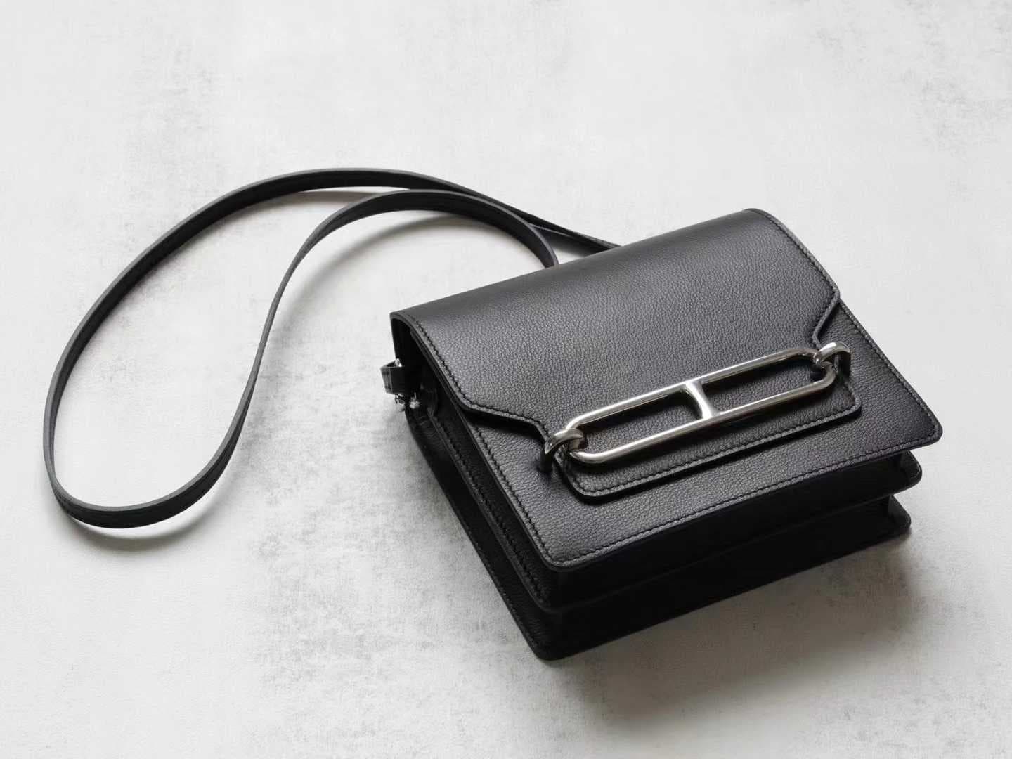 Front view of LINJIN LUXURY Roulis 18 shoulder bag in black Evercolor leather, showcasing the silver anchor-link buckle on a woven stool - 4