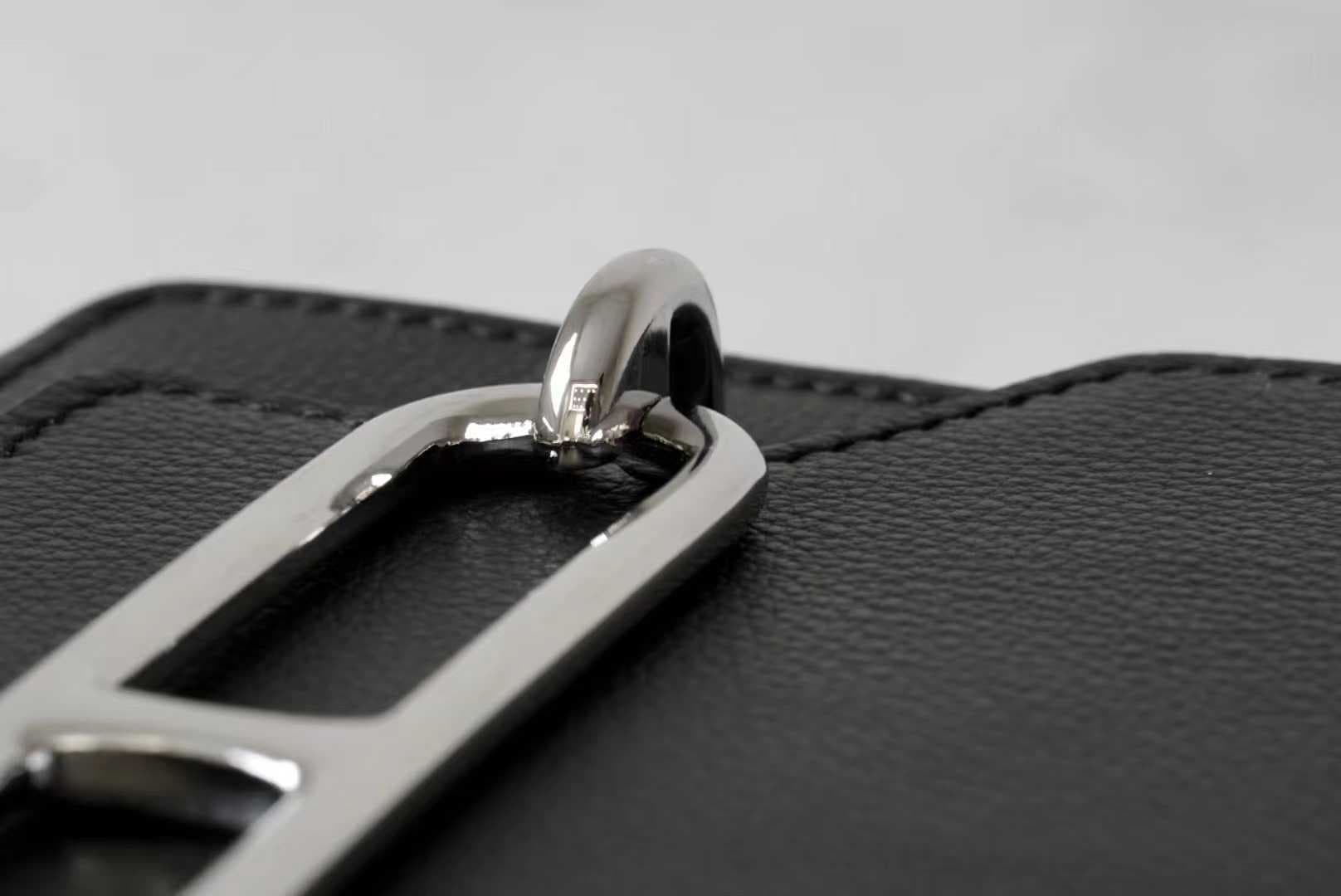 Front view of LINJIN LUXURY Roulis 18 shoulder bag in black Evercolor leather, showcasing the silver anchor-link buckle on a woven stool - 7