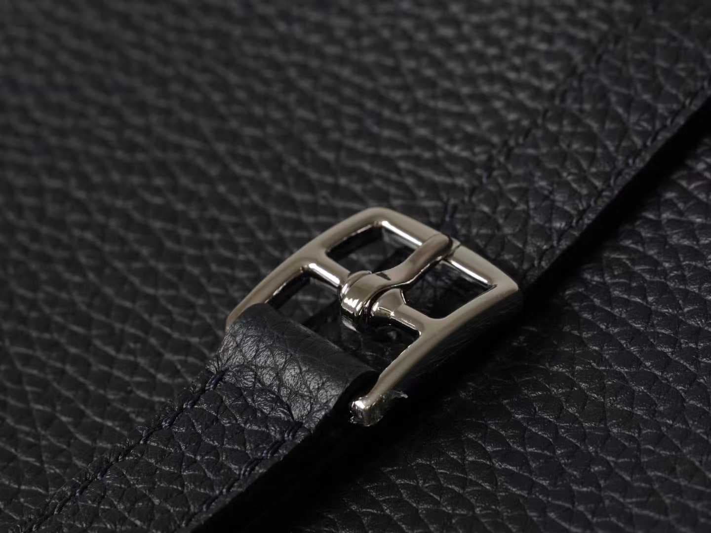 Minimalist black pebbled leather crossbody bag with a front buckle detail and long shoulder strap on a white background | LinJin - 6