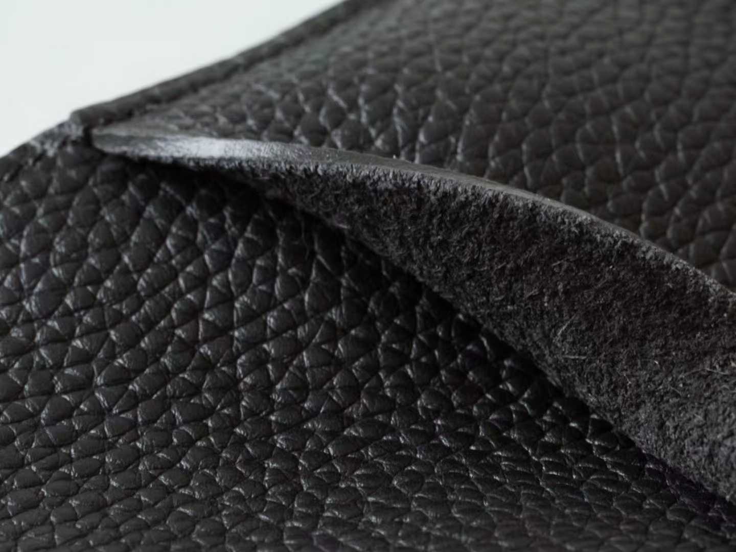 Minimalist black pebbled leather crossbody bag with a front buckle detail and long shoulder strap on a white background | LinJin - 7