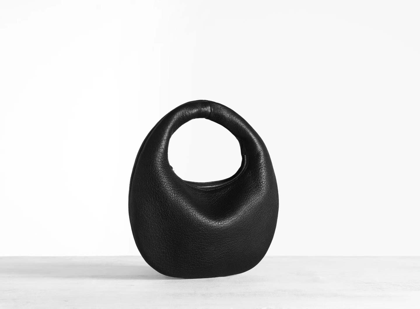 Linjin Luxury black pebbled deerskin lambskin crescent moon bag with single loop top handle and zip closure, minimal silhouette, displayed on a white surface - 2