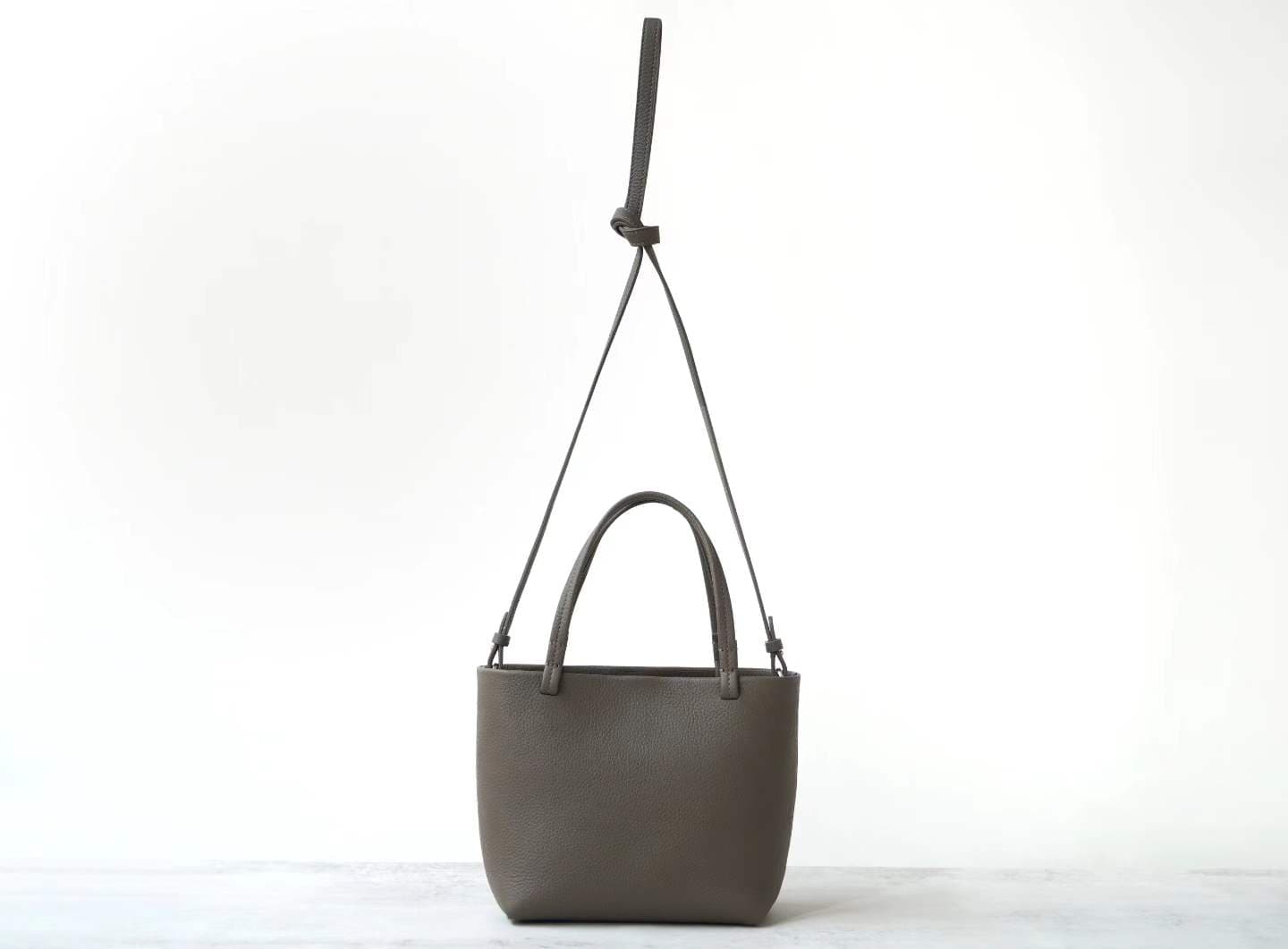 Linjin Luxury taupe pebbled cowhide oversized knotted tote bag with slim leather handles tied at top, minimal hardware-free design, on a white background - 4