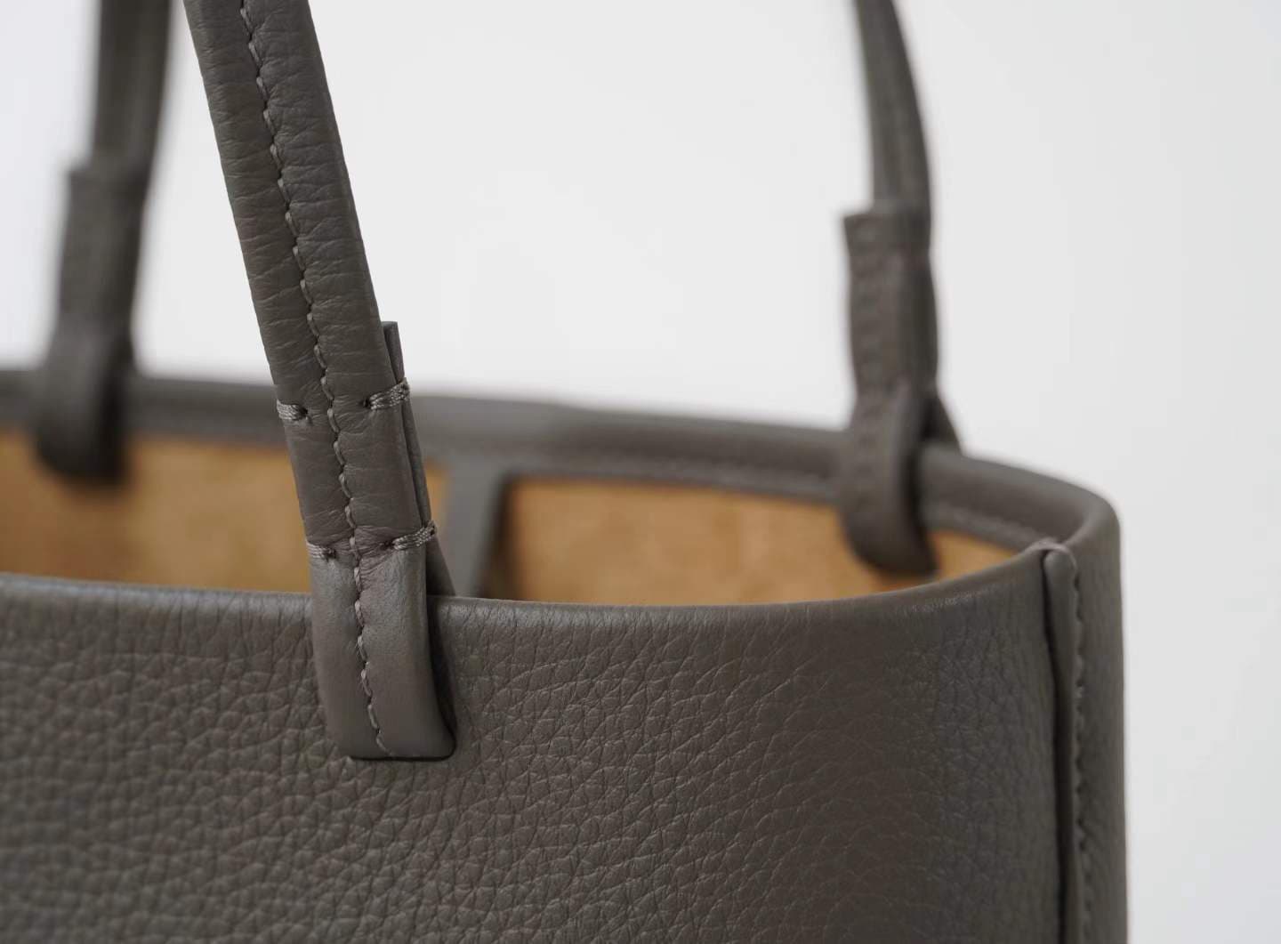 Linjin Luxury taupe pebbled cowhide oversized knotted tote bag with slim leather handles tied at top, minimal hardware-free design, on a white background - 9